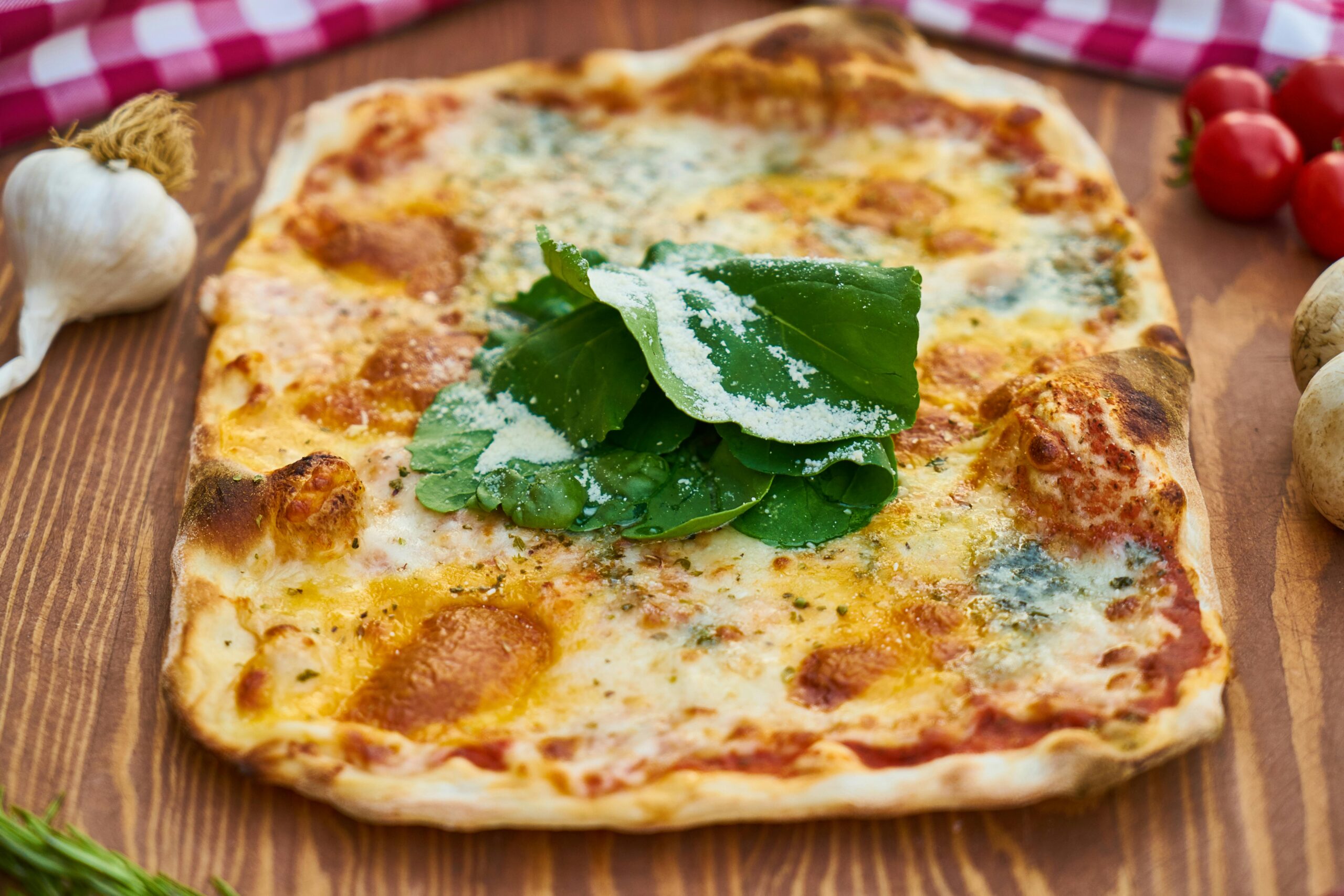 Close-up of a homemade pizza topped with arugula, mozzarella, and tomatoes.